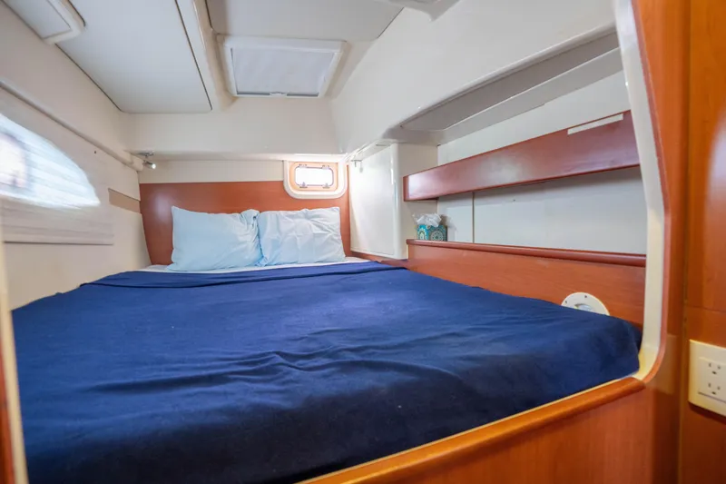 Lovely Cruise Yacht Photos Pics Cozy cabin interior of 2011 Leopard 38 yacht with blue bedding and wooden accents.
