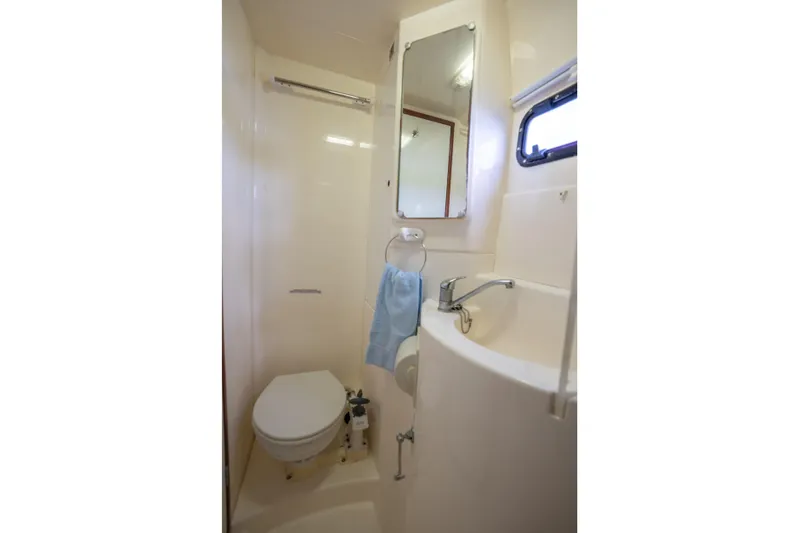 Lovely Cruise Yacht Photos Pics Compact bathroom in 2011 Leopard 38 yacht with toilet, sink, and mirror.