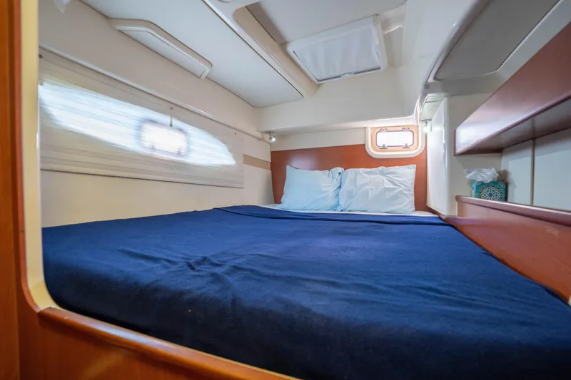 Lovely Cruise Yacht Photos Pics Cozy cabin interior of 2011 Leopard 38 yacht with blue bedding and wooden accents.