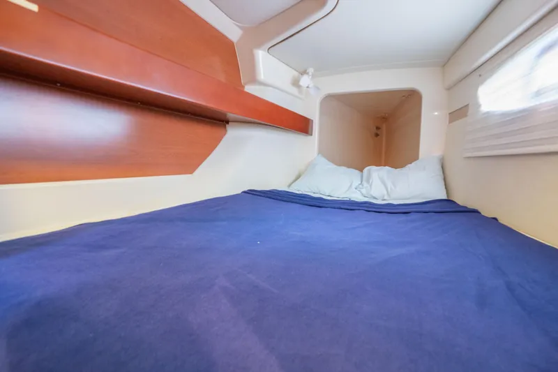 Lovely Cruise Yacht Photos Pics Cozy cabin interior of 2011 Leopard 38 yacht with blue bedding and wooden accents.