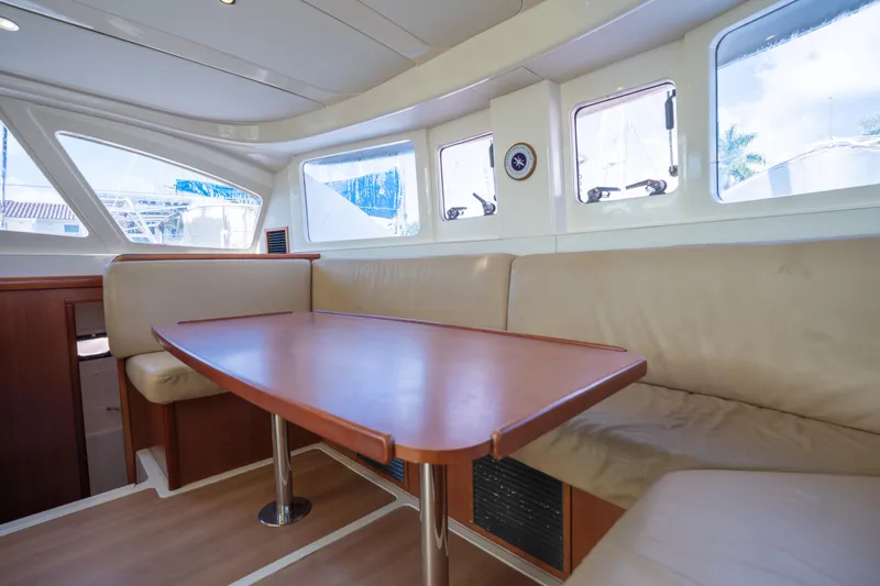 Lovely Cruise Yacht Photos Pics Interior of 2011 Leopard 38 yacht with beige seating and wooden table.