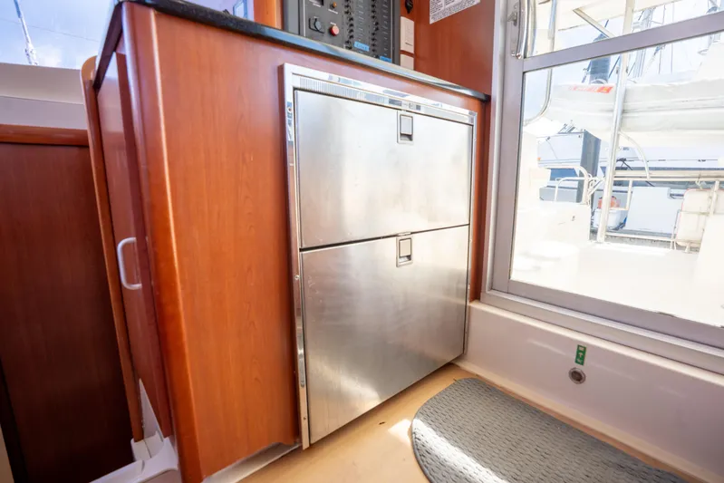 Lovely Cruise Yacht Photos Pics Interior of 2011 Leopard 38 yacht with stainless steel fridge and wooden cabinetry.