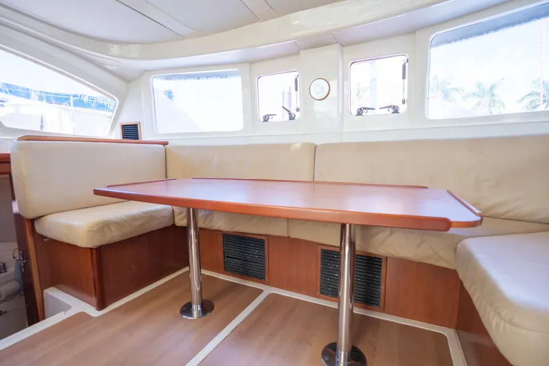Lovely Cruise Yacht Photos Pics Interior of 2011 Leopard 38 yacht with beige seating and wooden table.