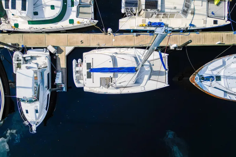 Lovely Cruise Yacht Photos Pics Aerial view of a 2011 Leopard 38 catamaran docked among other boats.