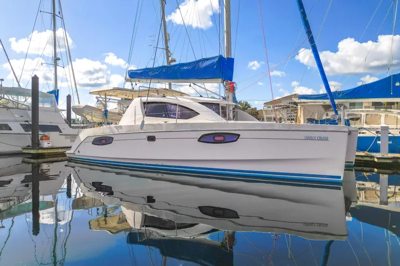Lovely Cruise Yacht Photos Pics 2011 Leopard 38 catamaran docked at marina, reflecting on calm water under blue sky.