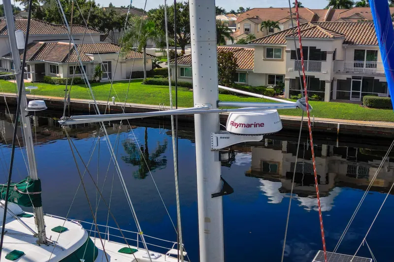 Lovely Cruise Yacht Photos Pics Sailboat mast with Raymarine equipment, Leopard 38 model, docked near waterfront homes.