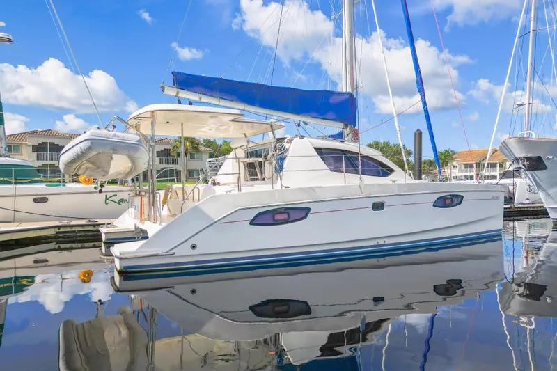 Lovely Cruise Yacht Photos Pics 2011 Leopard 38 catamaran docked in marina, blue sky reflection on water.