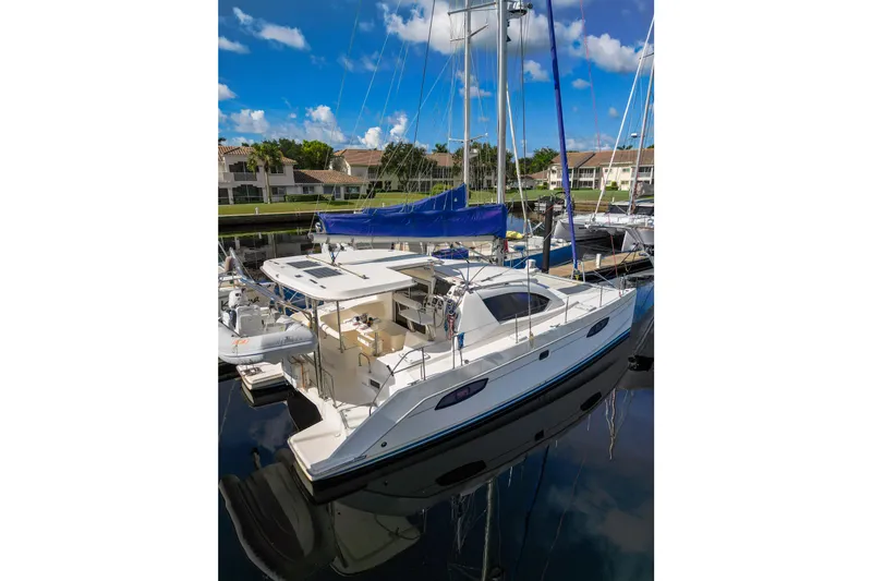 Lovely Cruise Yacht Photos Pics 2011 Leopard 38 catamaran docked in marina, blue sky, residential backdrop.