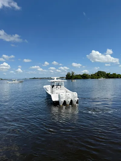 "here We Go" Yacht Photos Pics 2021 Sportsman Open 352 Center Console boat on calm water under blue sky.