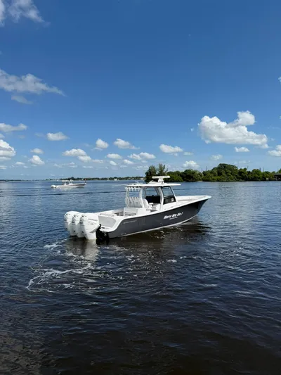 "here We Go" Yacht Photos Pics 2021 Sportsman Open 352 Center Console boat on calm water under blue sky.