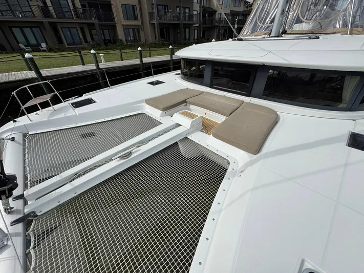 Eden Yacht Photos Pics 2022 Lagoon 46 catamaran with netted deck and cushioned seating area.