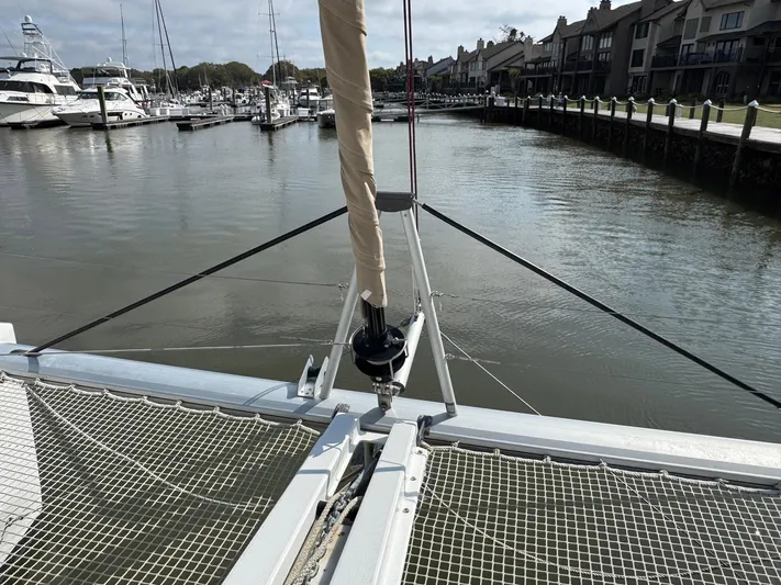Eden Yacht Photos Pics Lagoon 46 catamaran (2022) docked in a marina, showcasing its netted bow area.
