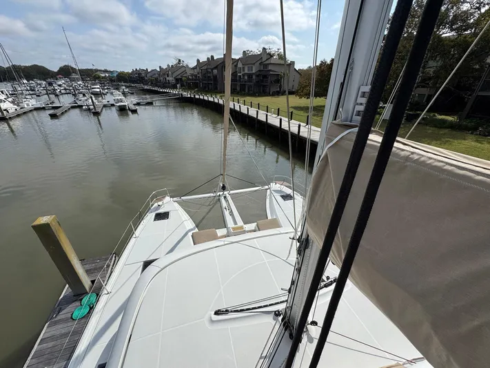 Eden Yacht Photos Pics 2022 Lagoon 46 catamaran docked in a marina with surrounding boats and waterfront homes.