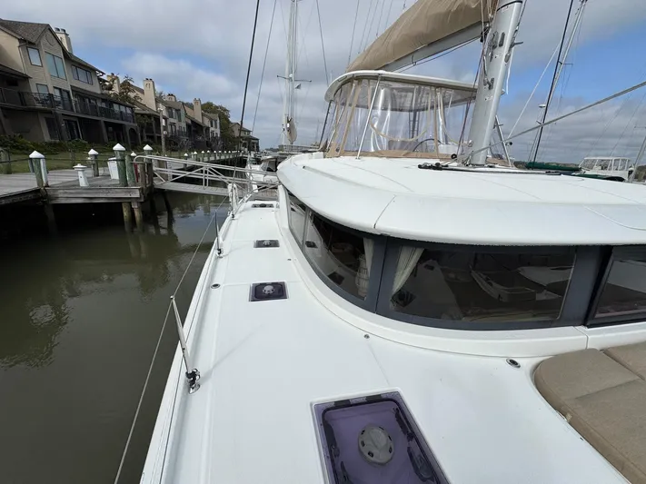Eden Yacht Photos Pics 2022 Lagoon 46 catamaran docked at marina, showcasing sleek design and spacious deck.