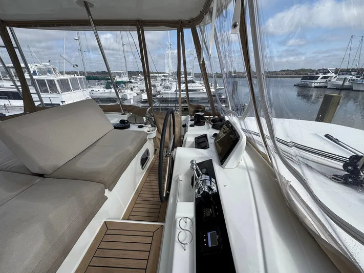Eden Yacht Photos Pics 2022 Lagoon 46 yacht interior with helm, seating, and marina view.
