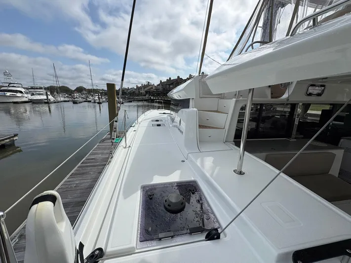 Eden Yacht Photos Pics 2022 Lagoon 46 catamaran docked at marina, showcasing sleek deck design and spacious layout.
