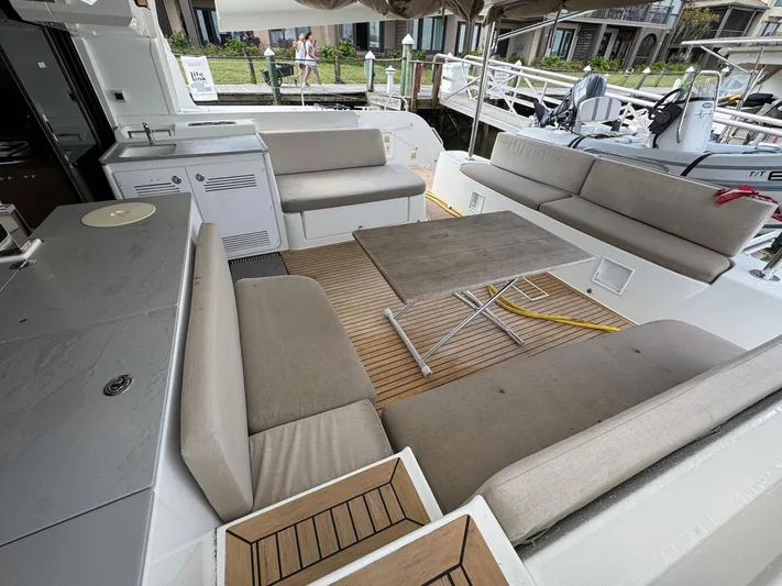 Eden Yacht Photos Pics Spacious outdoor seating area on a 2022 Lagoon 46 catamaran, featuring comfortable cushions and a table.