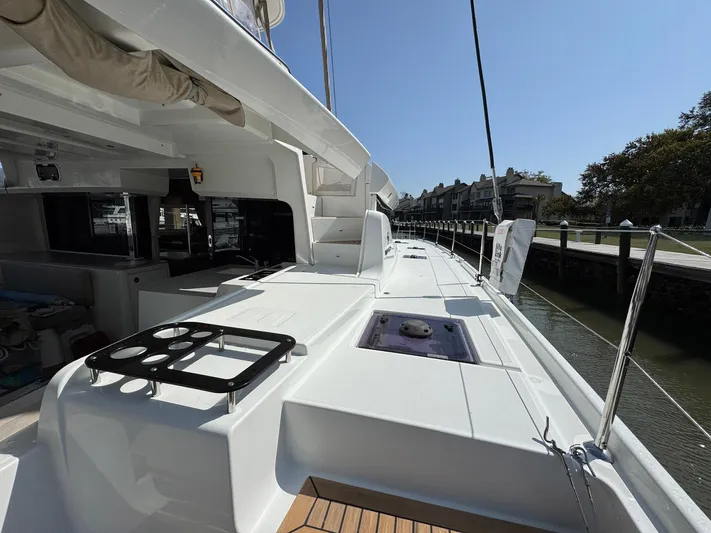 Eden Yacht Photos Pics 2022 Lagoon 46 catamaran deck, featuring sleek design and spacious layout in marina setting.