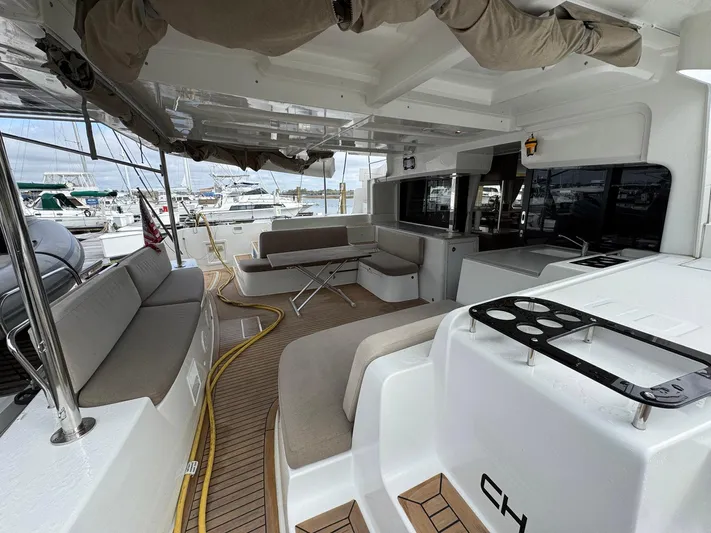 Eden Yacht Photos Pics Spacious deck of 2022 Lagoon 46 catamaran with seating and marina view.
