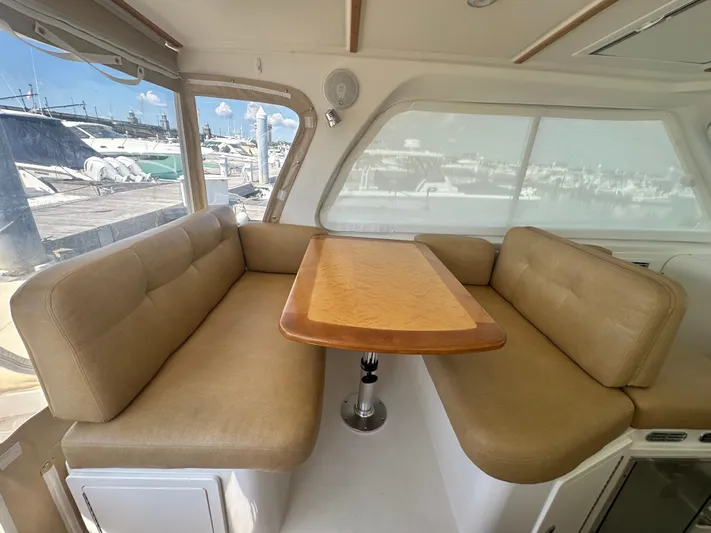 Reveille Yacht Photos Pics Interior of 2013 Back Cove 34 boat with beige seating and wooden table.