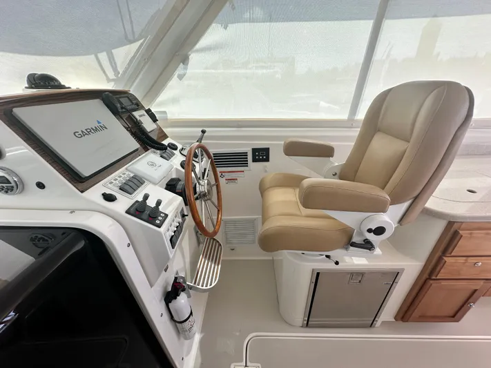 Reveille Yacht Photos Pics 2013 Back Cove 34 helm with Garmin navigation, beige captain's chair, and wooden cabinetry.