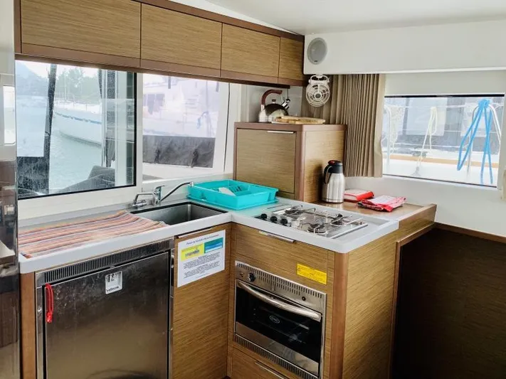 Unicorn Yacht Photos Pics Modern kitchen interior of 2019 Lagoon 40 catamaran with stove, sink, and window view.