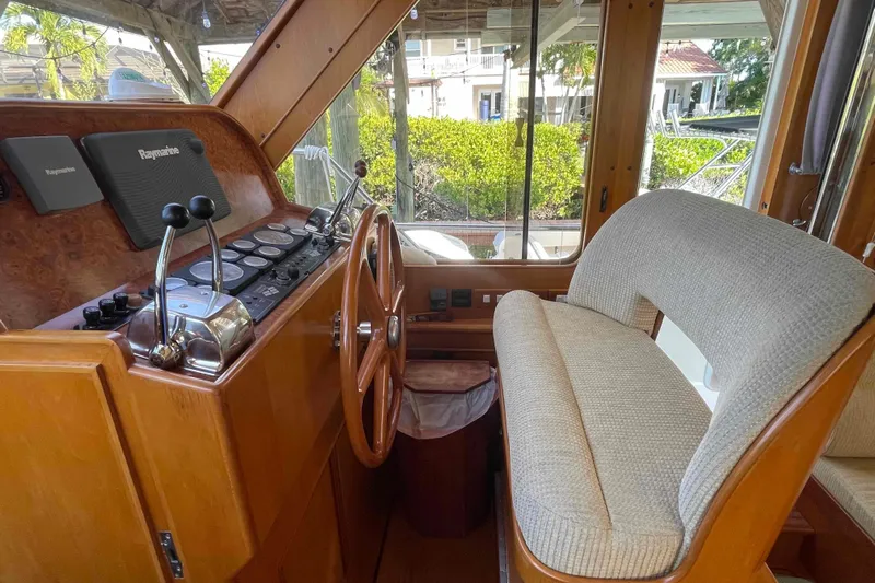Free Ride Yacht Photos Pics 2002 President Trawler helm with wooden steering wheel and Raymarine navigation system.