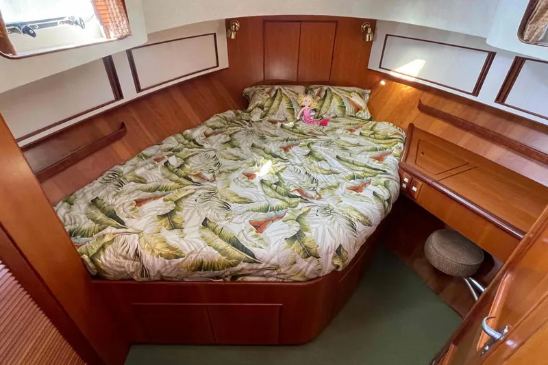 Free Ride Yacht Photos Pics Cozy cabin interior of 2002 President Trawler with tropical bedding and wooden furnishings.