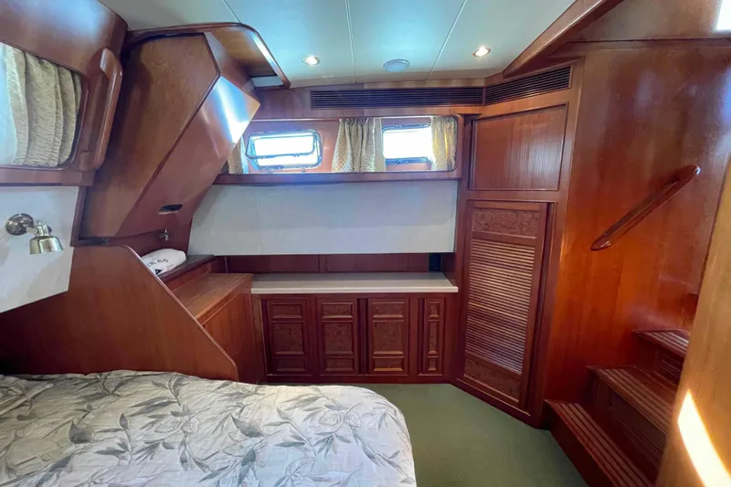 Free Ride Yacht Photos Pics Luxurious 2002 President Trawler cabin with elegant wood paneling and cozy bedding.