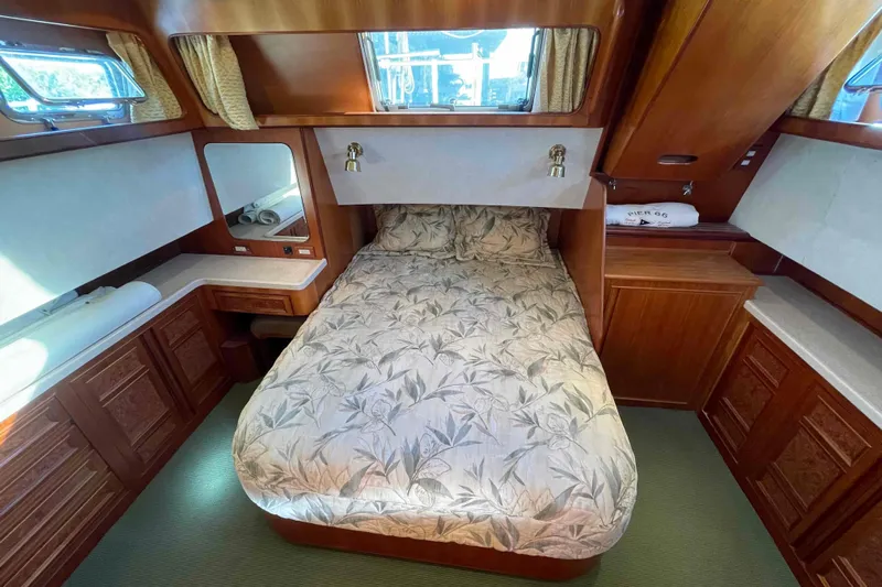 Free Ride Yacht Photos Pics Luxurious 2002 President Trawler cabin with elegant wood finish and cozy bedding.