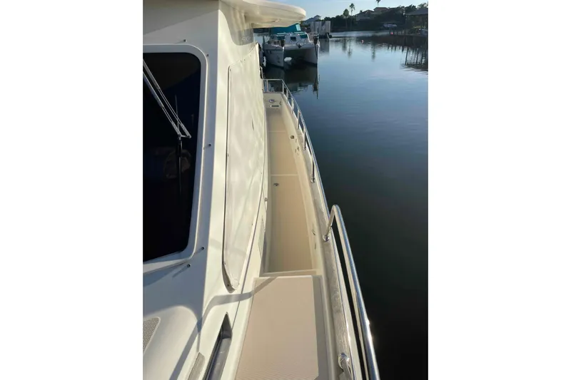 Free Ride Yacht Photos Pics 2002 President Trawler yacht deck with railing, docked by calm waters.
