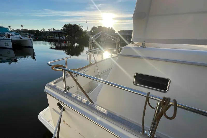 Free Ride Yacht Photos Pics 2002 President Trawler docked at sunset, reflecting on calm water.