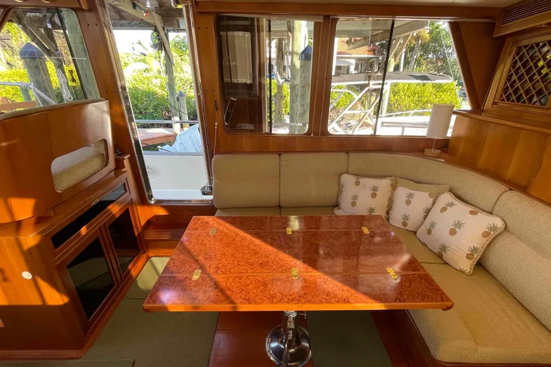 Free Ride Yacht Photos Pics Interior of 2002 President Trawler with elegant wood table and cushioned seating.