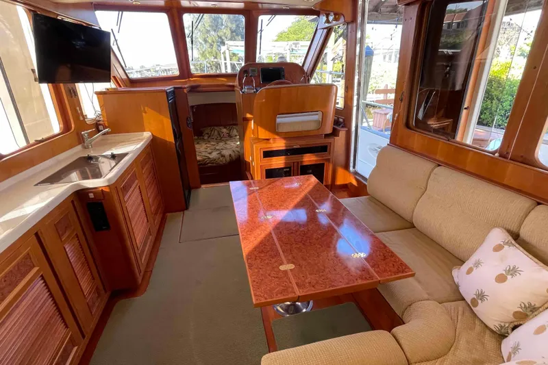 Free Ride Yacht Photos Pics Luxurious 2002 President Trawler interior with cozy seating, dining table, and kitchenette.