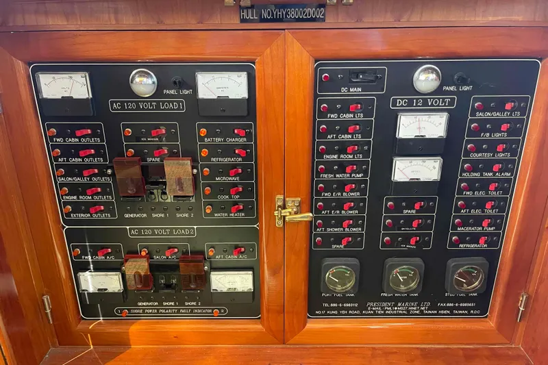 Free Ride Yacht Photos Pics Electrical control panel on a 2002 President Trawler boat, featuring AC and DC voltage systems.