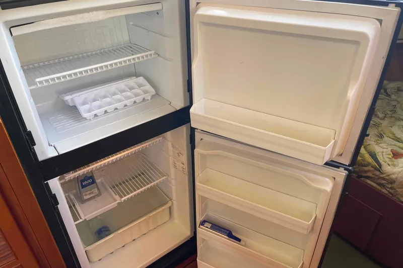 Free Ride Yacht Photos Pics Open refrigerator in a 2002 President Trawler, showing empty shelves and ice tray.