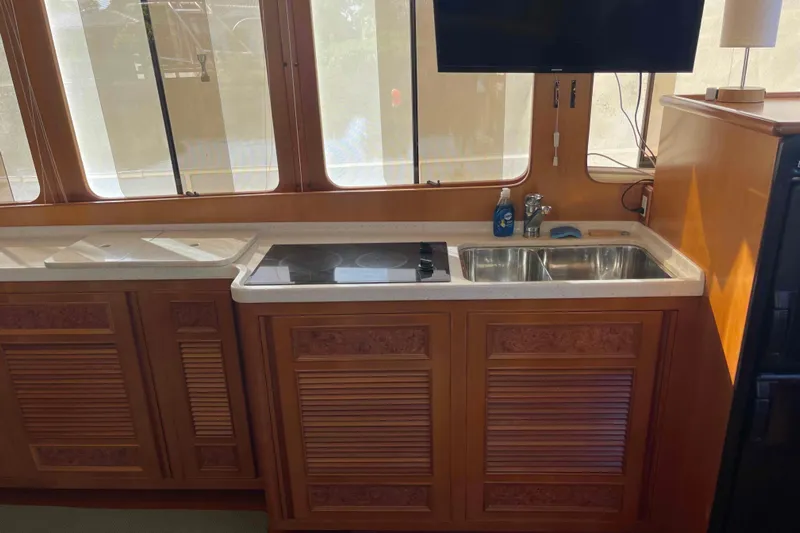 Free Ride Yacht Photos Pics Kitchen area in a 2002 President Trawler with stove, sink, and wooden cabinetry.