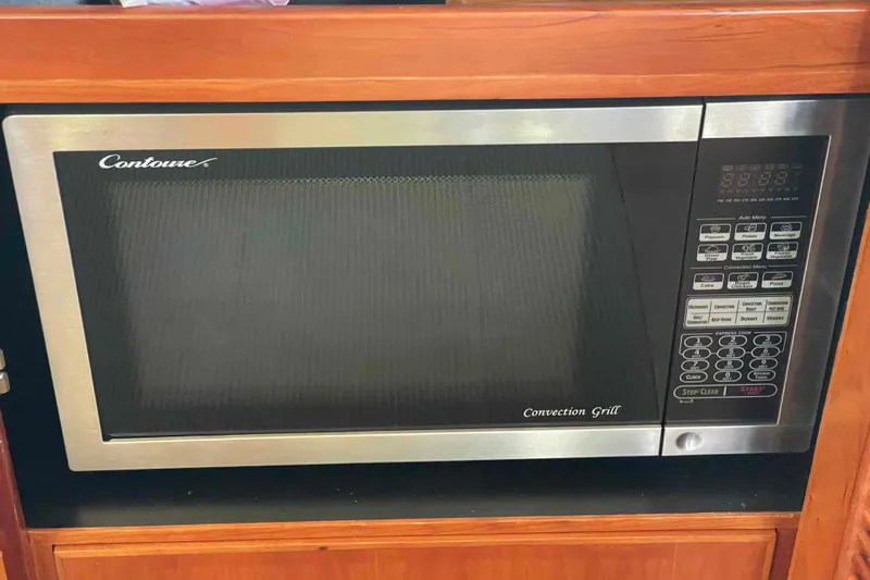 Free Ride Yacht Photos Pics Contoure convection grill microwave in wooden cabinet, featuring digital controls and stainless steel finish.