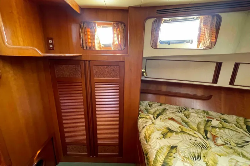 Free Ride Yacht Photos Pics Cozy cabin interior of 2002 President Trawler with wooden finishes and patterned bedding.