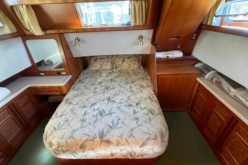 Free Ride Yacht Photos Pics Cozy bedroom in 2002 President Trawler with wood cabinetry and floral bedding.