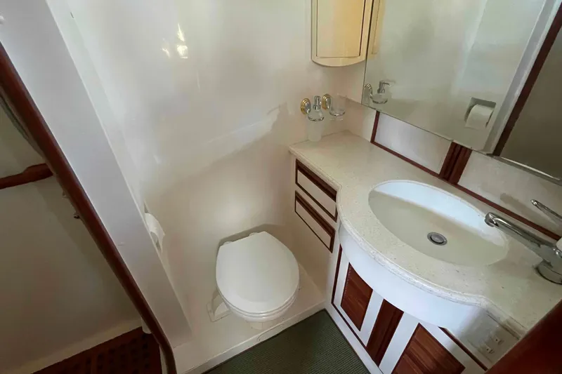 Free Ride Yacht Photos Pics Compact bathroom in 2002 President Trawler with sink, toilet, and wooden accents.