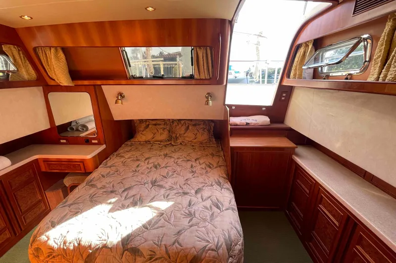 Free Ride Yacht Photos Pics Luxurious 2002 President Trawler cabin with elegant wood finish and cozy bedding.