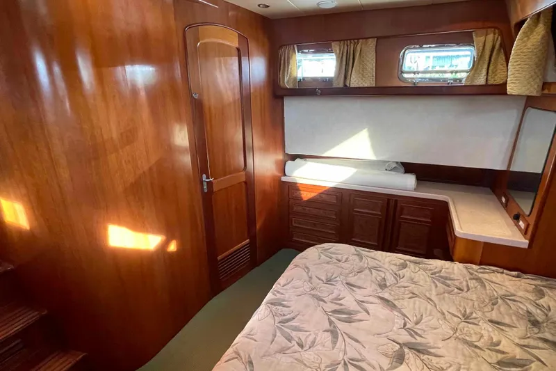 Free Ride Yacht Photos Pics Luxurious 2002 President Trawler cabin with wood paneling and cozy bedding.