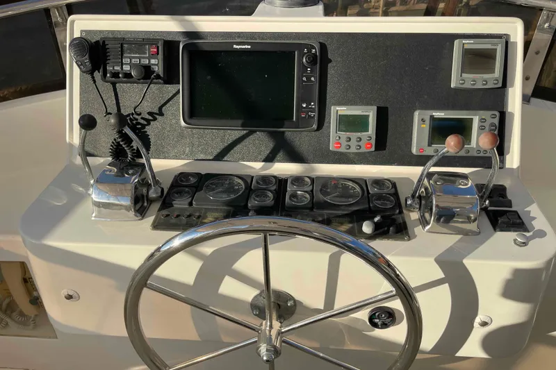 Free Ride Yacht Photos Pics Control panel of a 2002 President Trawler with navigation instruments and steering wheel.