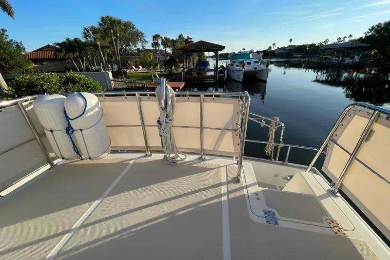 Free Ride Yacht Photos Pics 2002 President Trawler deck overlooking serene marina with docked boats and lush greenery.