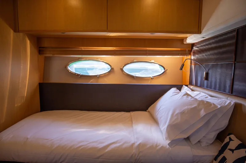  Yacht Photos Pics Luxurious cabin interior of 2012 Princess V72 yacht with cozy bed and porthole windows.