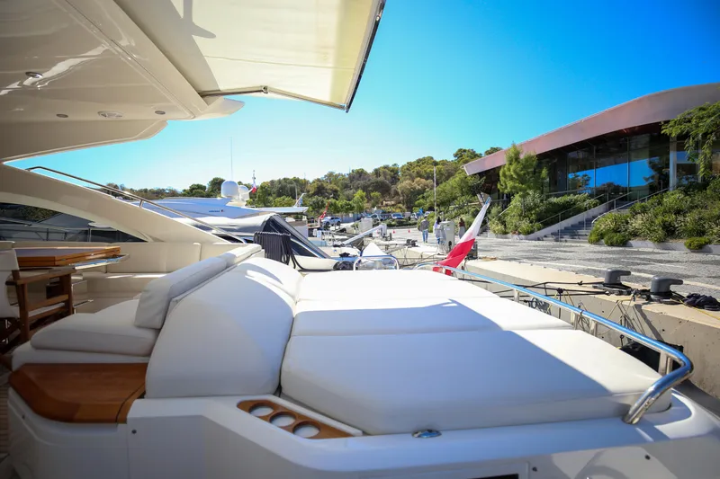  Yacht Photos Pics Luxurious 2012 Princess V72 yacht docked, featuring elegant white seating and scenic marina view.