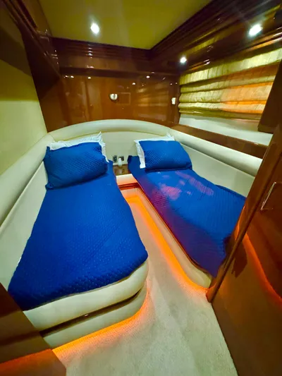  Yacht Photos Pics Luxurious twin cabin in 2006 Marquis 65 yacht with blue bedding and ambient lighting.