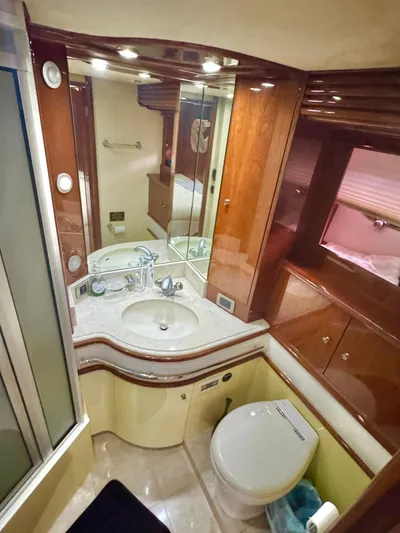  Yacht Photos Pics Luxurious bathroom in a 2006 Marquis 65 yacht with elegant wood cabinetry and modern fixtures.