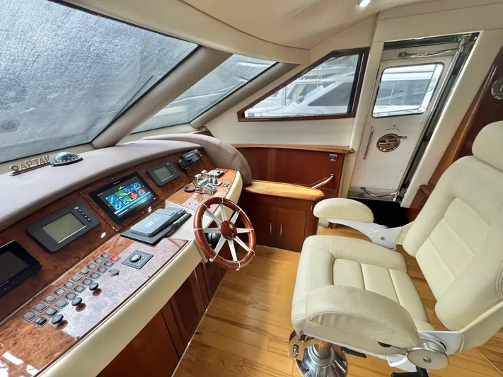  Yacht Photos Pics Luxurious 2006 Marquis 65 yacht helm with leather chair and advanced navigation controls.